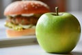 a hamburger and a green apple