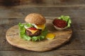 Hamburger isolated with fried egg on a wooden rustic background with copy space for text.