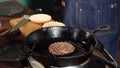 A hamburger patty frying on a cast iron grill. Stock footage. Hamburger Patty is prepared on the grill pan