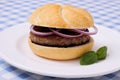 Hamburger on plate, on white blue checkered tablecloths Royalty Free Stock Photo