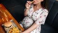 Hamburger pregnancy girl eat. Pretty happy pregnant woman eating tasty burger. Junk food concept. Royalty Free Stock Photo