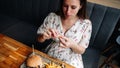 Hamburger pregnancy girl eat. Pretty happy pregnant woman eating tasty burger. Junk food concept. Royalty Free Stock Photo