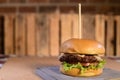 Hamburger sandwich with open brioche bread cream cheese fries bacon sauces on the table on blurred background