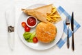 Hamburger, tomato sauce, and fried potatoes in a paper bag on a white plate Royalty Free Stock Photo