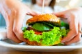 Hamburger vegan healthy vegetarian burger. Salad, avocado, vegetable on veggie sandwich eating cute woman. Tasty