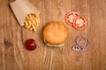 Hamburger on the wooden table with french fries. Delicious lunch with cheese, tomatoos and salad