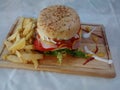 HAMBURGER ON WOODEN TABLE WITH FRIED POTATOES AND SAUCES OF VARIOUS COLORS AND FLAVORS IS A FAST OR CHATARRA FOOD