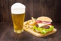 Hamburgers with beer on the wooden table Royalty Free Stock Photo