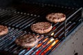 Hamburgers on Grill with Dancing Flames Cooked to Perfection.Beef or pork meat barbecue burgers for hamburger prepared Royalty Free Stock Photo