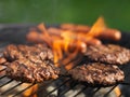 Hamburgers and hotdogs cooking on grill outdoors Royalty Free Stock Photo