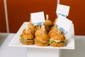 Hamburgers lie on a white plate, with beautiful signs for signatures.