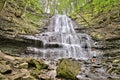 A young woman cools off the summer heat in a waterfall in the summer