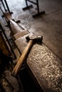 Hammer, anvil and blacksmith workplace in a iron factory and industrial workshop. Tools, metal work and steel artisan Royalty Free Stock Photo