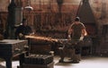 Hammer, anvil and sparks with men working in a forge for metal work manufacturing or production. Industry, welding and