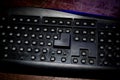 Hammer on computer keyboard with damaged keys