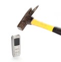 Hammer crashing an old cell phone on a white background Royalty Free Stock Photo