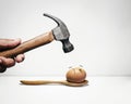 Hammer and egg with anxious face Royalty Free Stock Photo