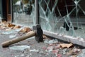 hammer on the ground next to a shattered shopfront