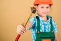 Hammer in hand of small girl repairing in workshop. Foreman inspector. Little girl in helmet with hammer. Kid worker in