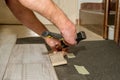 Hammer held by a person`s hand with amputated fingers as he works laying flooring in his home. Physical disability concept.