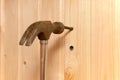 hammer hits the dowel and hammers it into a hole in the wooden wall