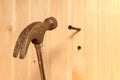 A hammer hits the dowel and hammers it into a hole in the wooden wall