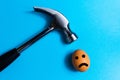 Hammer is hitting on an egg with blue background. minimal idea creative concept. Royalty Free Stock Photo