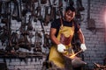 Hammer industry small business concept.african american man dressed in historical clothing is hammering on the anvil. A