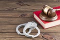 Hammer of a judge, book, handcuffs on a wooden background. Royalty Free Stock Photo