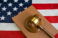 Hammer of the judge on the book of laws, the background of the flag of the United States of America. Royalty Free Stock Photo