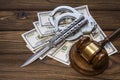 Hammer of a judge; knife; handcuffs and money dollars on a wood texture background. Royalty Free Stock Photo