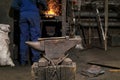 The hammer lies on the anvil in the forge while the blacksmith went to the furnace