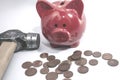 The hammer lies next to a red piggy bank and a bunch of euro coins. Foreground. The concept of shopping, savings, crisis,