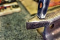 Hammer on a metal anvil in a workshop. Close-up of metalworking tools.