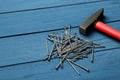 Hammer and metal nails on blue wooden table, space or text Royalty Free Stock Photo