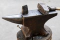 A hammer and a metal object on an anvil. Tools and metal objects used by the blacksmith in a blacksmith shop Royalty Free Stock Photo