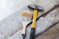 A hammer and a molar brush lie on a wooden board. Tools for interior and exterior decoration. Close-up Royalty Free Stock Photo