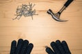 Hammer nails and gloves on wooden background. Royalty Free Stock Photo