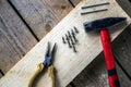 Hammer, nails, thin-nose pliers, screws on a wooden bar Royalty Free Stock Photo