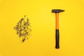 Hammer and pile of nails on yellow background Royalty Free Stock Photo