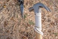 Hammer putting a nail-like tent peg out of iron into the grass on the ground. Push the anchor of the tent onto the ground.Travel