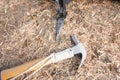 Hammer putting a nail-like tent peg out of iron into the grass on the ground. Push the anchor of the tent onto the ground.Travel