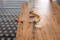 Hammer, ruler with angle bar, tape meter and other tool on laminate vinyl floor