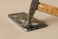 A hammer smashing a mobile phone on a grey background Royalty Free Stock Photo