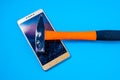 Hammer Smashing Smart Phone on blue background