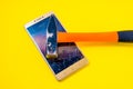 Hammer Smashing Smart Phone on yellow background