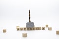 The hammer is standing on the wooden cubes with the word AUTHORITY against white background