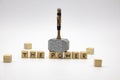 The hammer is standing on the wooden cubes with the words THE POWER against white background
