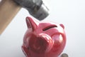 The hammer is about to break the red piggy bank with coins. View from above. The concept of finding money, crisis, poverty