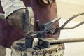 Hammer and tongs in the hands of a blacksmith, a close-up of a blacksmith`s work a historical recreation